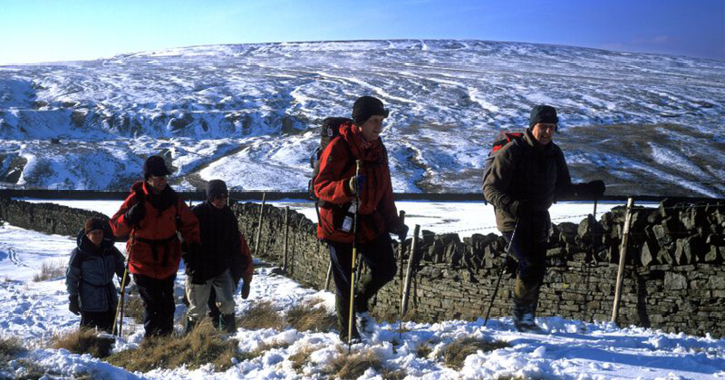 group of people walking through the snow covered North Pennines AONB